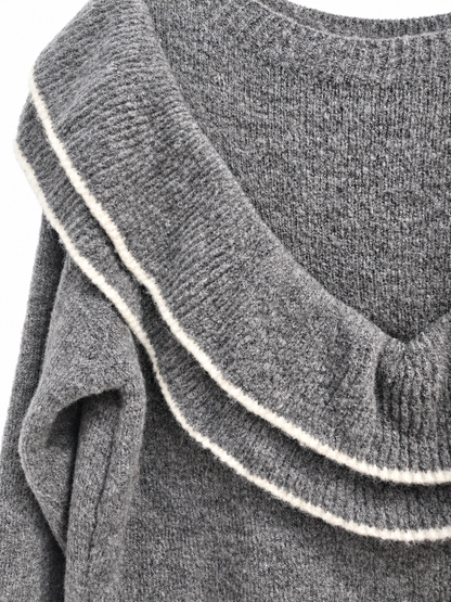 Détail du double volant liseré blanc du pull gris