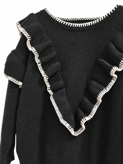 Détail des volants et des surpiqûres blanches du pull noir