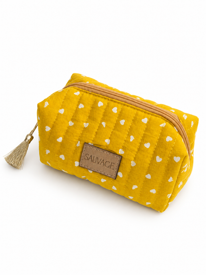 Trousse SAUVAGE jaune moutarde matelassée avec pompon doré, vue de trois quarts