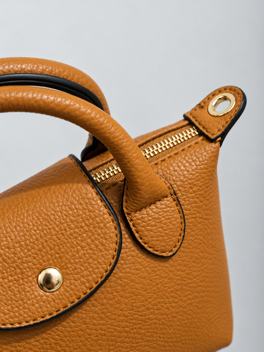 Détail du sac camel : zip doré, rabat et anse
